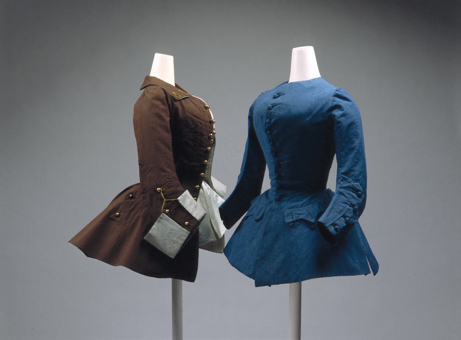 Two eighteenth-century women's riding coats, one brown and one blue, on dress forms